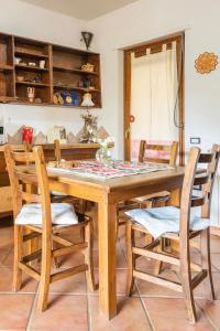UrzuleiB&B Su Biancu - Sardinian Experience的一间带木桌和椅子的用餐室