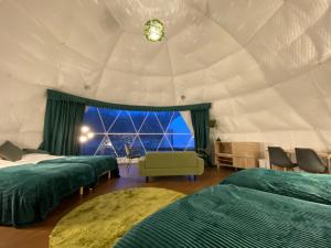 TomamuGRAMPING STAY TOMAMU的一间设有三张床的房间和一个位于帐篷的窗户