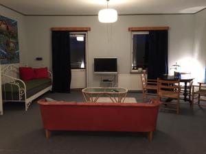 VitabyVitaby Järnvägshotell的客厅配有红色的沙发和桌子