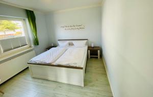 赛巴特班森Apartment Nähstube的卧室配有白色的床和窗户