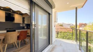 库萨达斯PALM BEACH APARTMENT的厨房设有滑动玻璃门,可通往阳台