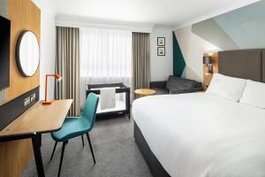 贝克斯利伦敦-贝克斯利假日酒店的酒店客房配有一张床、一张桌子和一把椅子。