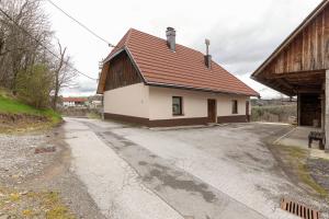 波斯托伊纳Počitniška Hiša Pr Martinovih的公路上一座棕色屋顶的建筑