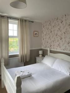 瓦伊河畔罗斯岔路上的旅馆的卧室配有白色的床和窗户。