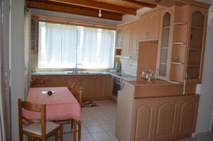 扎金索斯镇阿纳斯塔西娅公寓的厨房配有桌子和小桌子及椅子