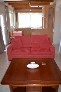 扎金索斯镇阿纳斯塔西娅公寓的客厅里一张红色的沙发,配有茶几