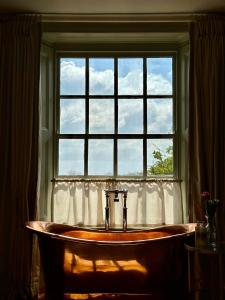 奥克姆The Barnsdale, Rutland的浴缸位于窗户前