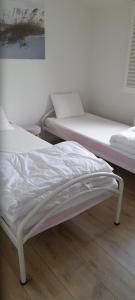 克诺克－海斯特de blinker的配有白色床单的客房内的两张床