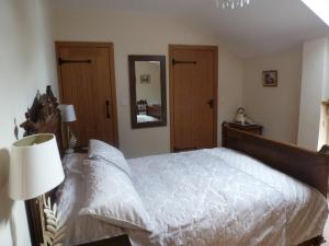 南特威奇Mile House Barn Bed & Breakfast的一间卧室配有一张大床和镜子