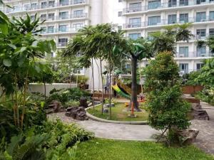 马尼拉Aveline Suites Cozy Skyline View ACQUA Private Residences near Rockwell Makati的公园在带游乐场的建筑前