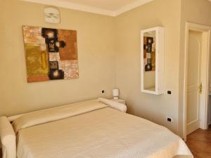 圣特雷莎加卢拉La chicca del porto的卧室配有一张床,墙上挂有绘画作品