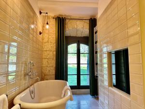 阿姆博斯阿邦迪斯城堡酒店的带浴缸的浴室和窗户。