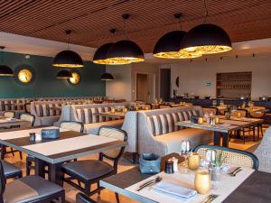 科尔马欧洲酒店的一间带桌椅和灯光的餐厅