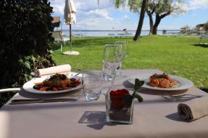西尔米奥奈芳提波伊欧拉酒店的一张桌子,上面放着两盘食物和酒杯