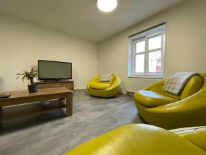奥帕瓦Central Apartments Opava的客厅设有黄色沙发和电视
