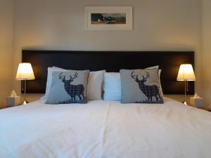 格伦科Glencoe view lodge的一张带两个鹿枕头的白色床