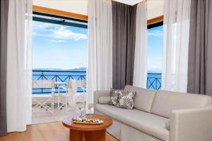 马蒂Ramada by Wyndham , Athens Club Attica Riviera的客厅配有沙发和桌子
