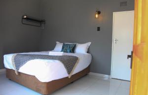 Pimville4447 Guesthouse的一间卧室配有带白色床单和枕头的床。