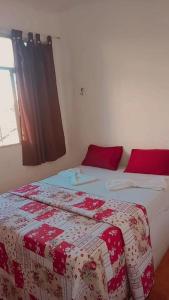 坎普斯戈伊塔卡济斯Pousada 146的一间卧室配有两张带红白毯子的床