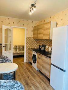 利耶帕亚Nākotnes street apartaments的厨房配有白色冰箱和桌子