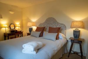 AldebyStackyard Lodge - enchanting 18th Century converted barn in the Waveney Valley的一间卧室配有一张大床和两盏灯