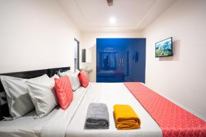 海得拉巴Yellow Bells Signature HITEC City的一间卧室配有一张带色彩缤纷枕头的大床