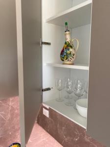 皮亚韦河畔诺文塔Residence Outlet Vivaldi的酒柜,酒杯和花瓶