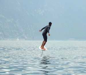 利莫内-苏尔加达Surf Hotel Pier - Montagnoli Group的水面冲浪板上身着湿衣服的人