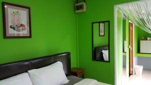 黎府ชมวิว รีสอร์ท的绿色卧室,配有床和绿色的墙壁