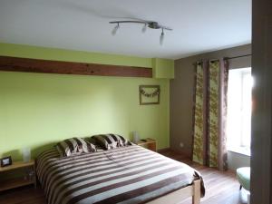 特镇Couleur Campagne的一间卧室设有一张带绿色墙壁的大床