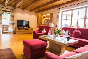 鲁波尔丁Ferienhaus Eva的客厅配有红色家具和电视