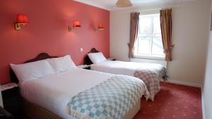 基尔罗南基尔默韦旅馆的红色墙壁的酒店客房内的两张床