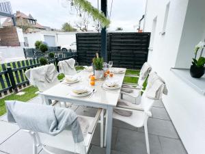 纽伦堡M-Style 01 Apartment mit Terrasse und Gasgrill, 24h Self-Check-In, Free Parking, Netflix的庭院里的白色桌椅