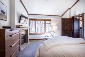 帕克城Hyatt at the Canyons by Lespri Management的一间卧室配有一张床、一台电视和一个壁炉