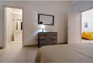 韦列Giardini Saraceni的一间卧室配有一张床、梳妆台和镜子