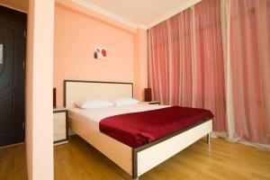 茨卡尔图博Chill Out Hotel的一间卧室配有一张带红色毯子的床