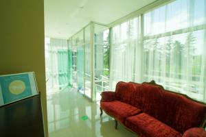 茨卡尔图博Chill Out Hotel的一个带大窗户的客房内的红色沙发