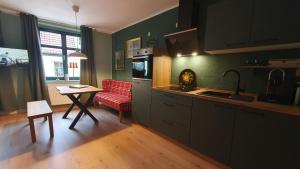 巴德马斯考Der grüne Fürst Ferienwohnung Appartement 1的厨房配有桌子和红色椅子