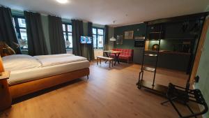 巴德马斯考Der grüne Fürst Ferienwohnung Appartement 1的一间卧室配有一张床、一间厨房和一张桌子