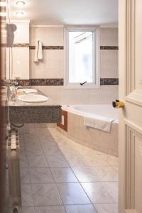圣马丁德洛斯巴塔哥尼亚广场酒店的带浴缸、水槽和窗户的浴室