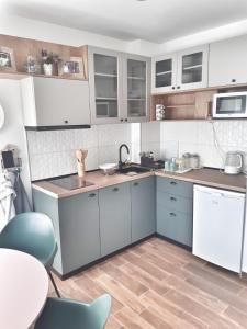 斯科普里Home Apartment LUNA的厨房配有白色和蓝色的橱柜和桌子