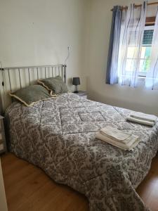 帕塔亚什Casa 28的一间卧室配有一张带毯子的床和窗户