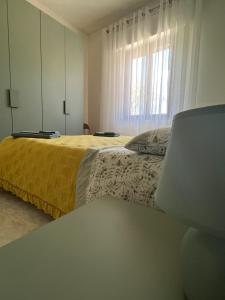 皮耶迪卢科La Cannucciola的一间卧室设有黄色的床和窗户。