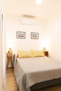 布拉加多LA CALMA - Eco Lodge Rural的白色卧室配有黄色枕头的床