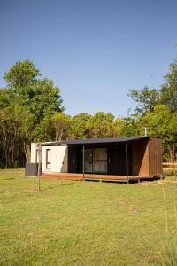 布拉加多LA CALMA - Eco Lodge Rural的一座小房子,位于一片树木林立的田野中