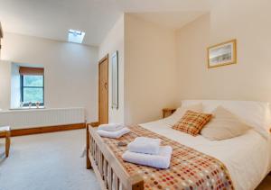 CemmaesBythynnod Aderyn Cottages的一间卧室配有一张大床和毛巾
