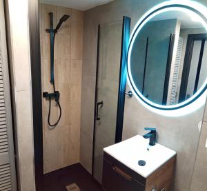 弗罗茨瓦夫Wroclove Airport Loft的带淋浴、盥洗盆和镜子的浴室