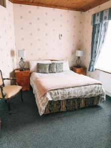 邓加文圣安东尼奥住宿加早餐旅馆的一间卧室配有一张大床和一把椅子