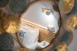 陶尔米纳Light Garden的床上的镜子反射,带枕头