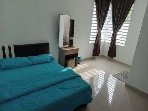 Batu LimaEMERALD VILLA HOMESTAY DUNGUN的一间卧室配有蓝色的床和电视